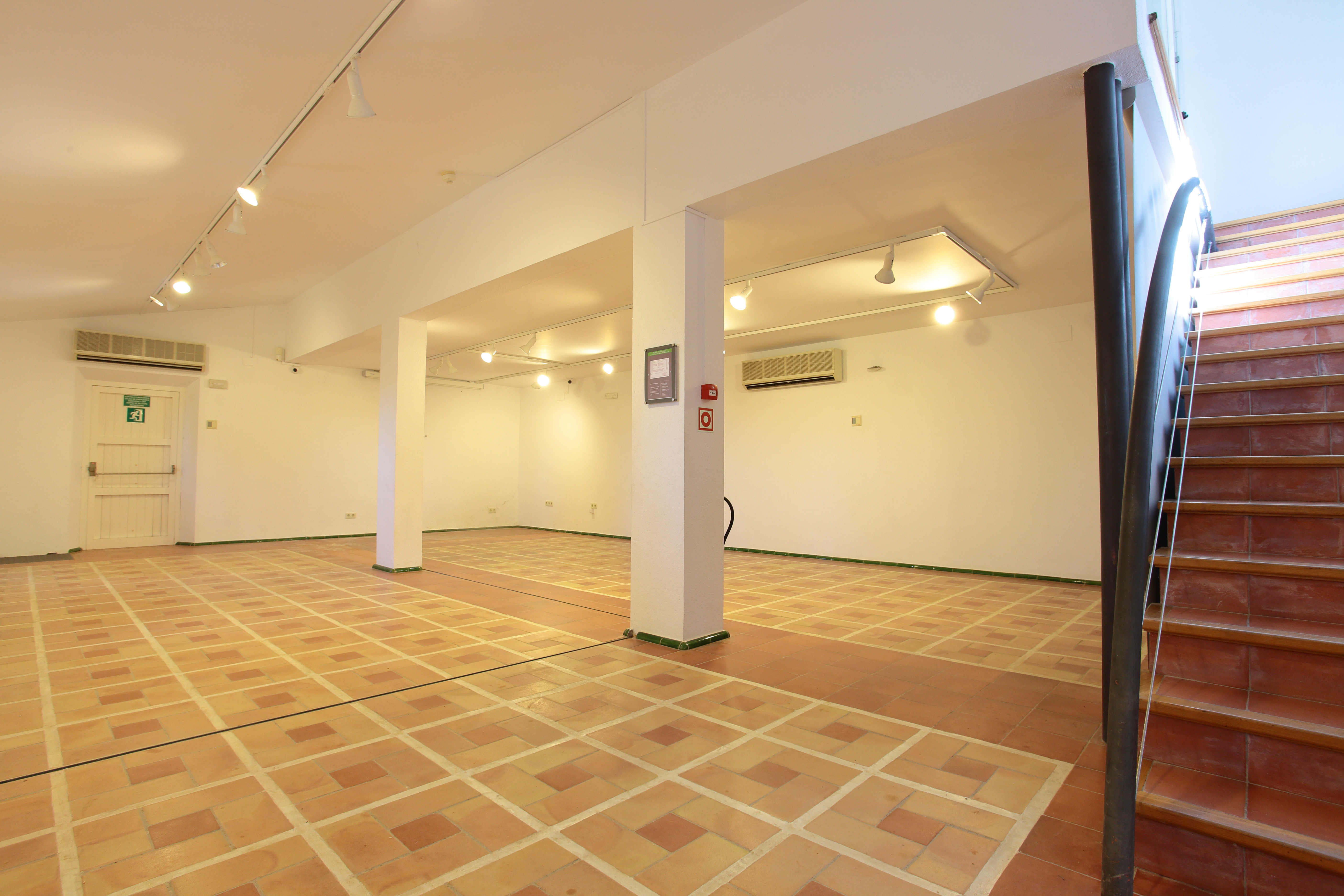 Sala buida amb escales a la dreta. 