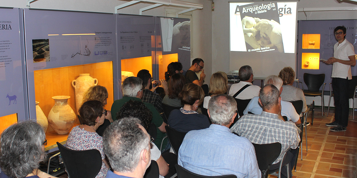 Sala d'un museu amb persones assegudes en cadires. 