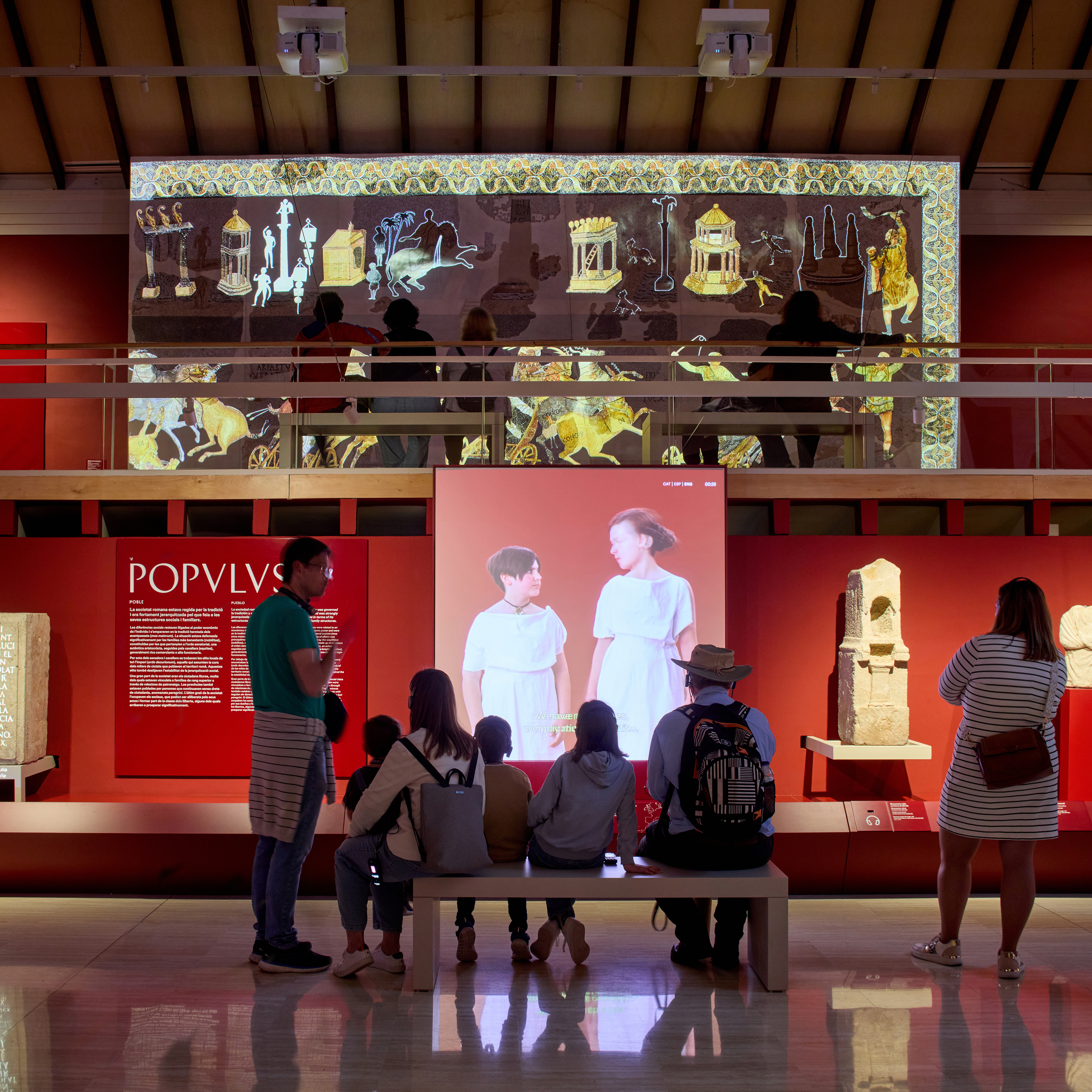 Un grup de visitants mirant un vídeo en una exposició