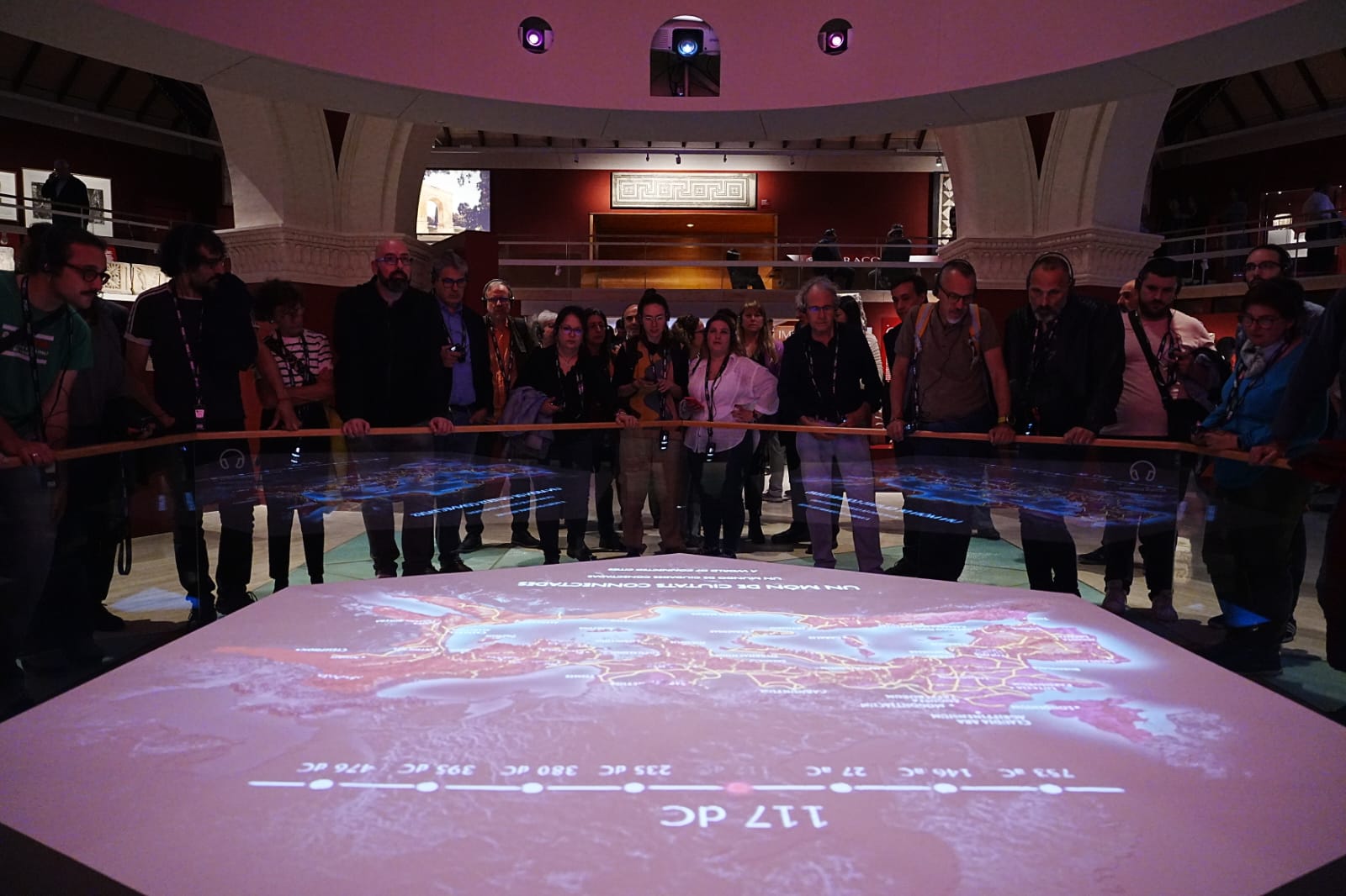 Un grup de persones observant un audiovisual en una exposició