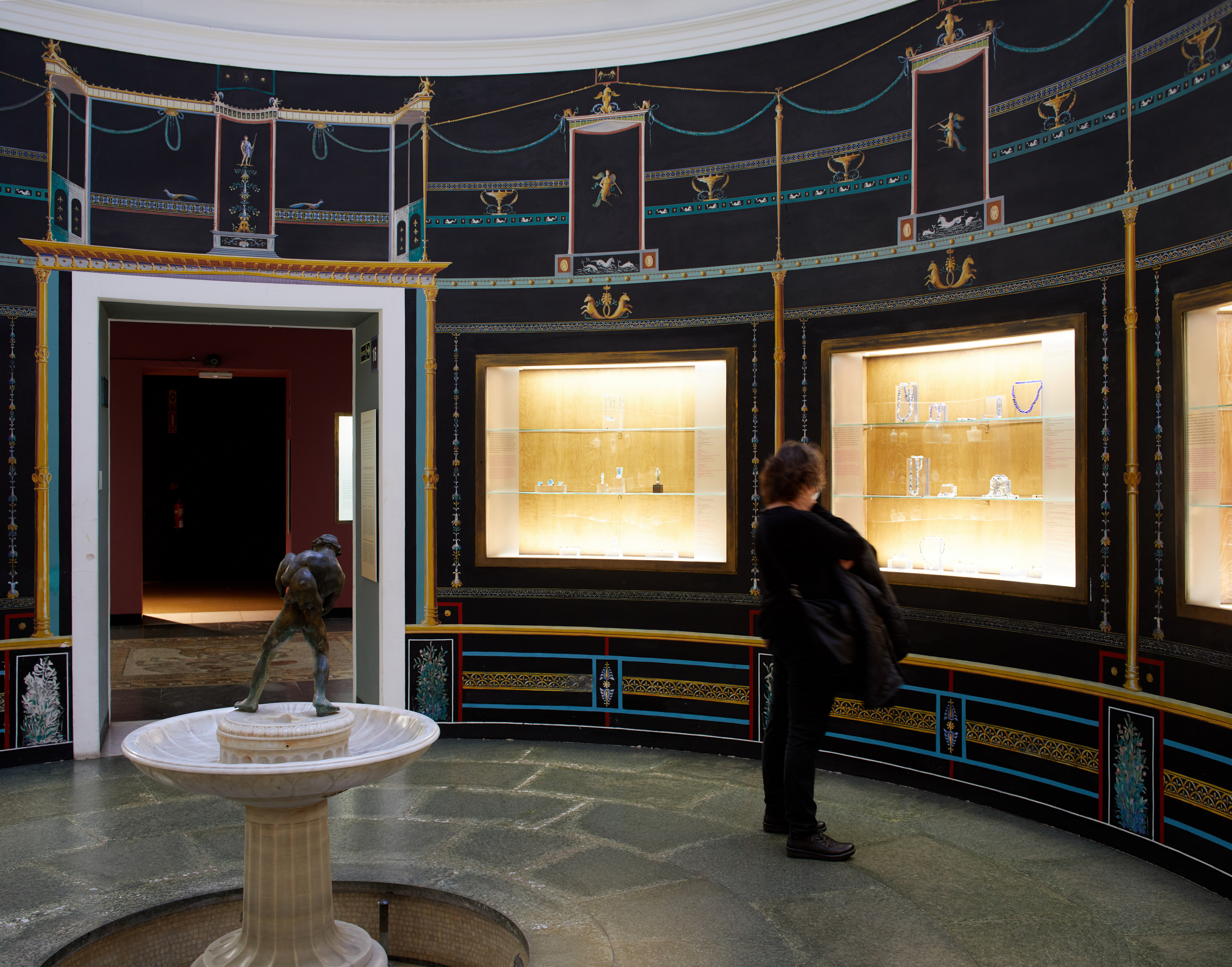 Visitant mirant les vitrinse de l'exposició Fragilitat en el temps.