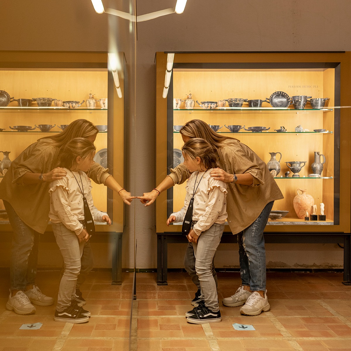 Mare i filla mirant unes vitrines de museu.
