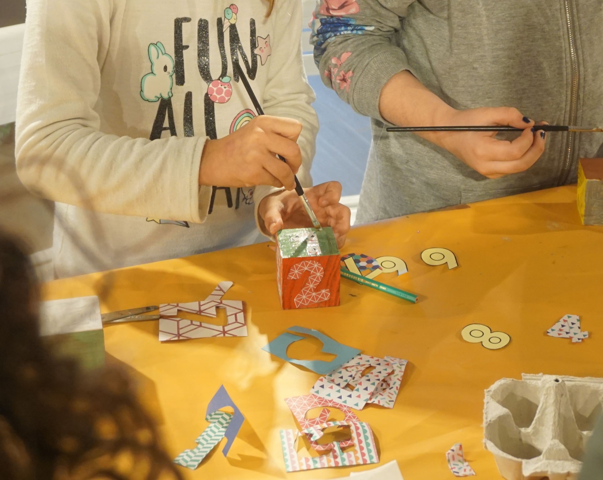 Infants amb pinzells a la mà realitzant una manualitat 