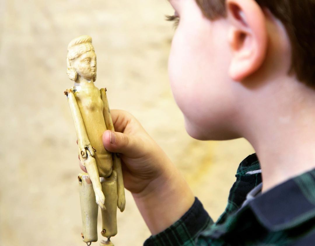 Un infant agafant una nina articulada